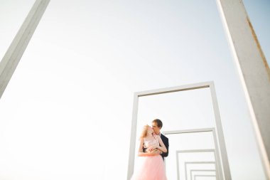 Çatıda mükemmel şehir manzaralı elele ve sarılma poz aşık genç bir çift. Güzel gün batımı