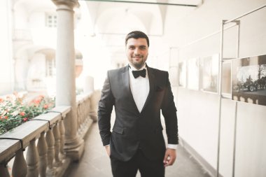 Arka plan eski kale üzerinde poz şık damat