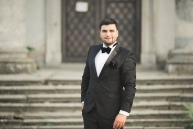 Arka plan eski kale üzerinde poz şık damat