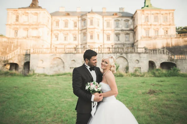 Feliz boda pareja abrazos y besos en el fondo viejo castillo — Foto de Stock