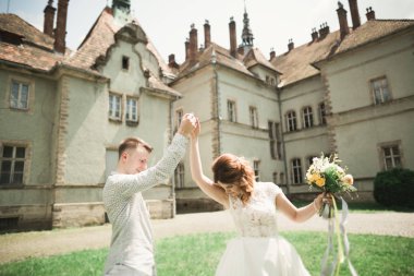 Sadece evli pozlar ve arka plan üzerinde eski bir kale ile öpüşme