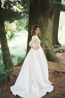 Gelin. Güzel sarışın kadın çiçek çelenk ve buket sıcak yaz gününde park