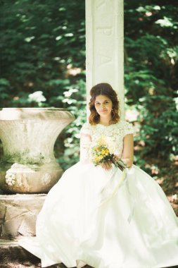 Gelin. Güzel sarışın kadın çiçek çelenk ve buket sıcak yaz gününde park