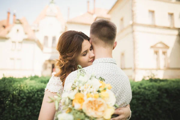 Beautiful fairytale newlywed couple hugging near old medieval castle — Stock Photo, Image