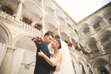 Güzel, mutlu bir düğün çifti, güzel şehirde uzun beyaz elbiseli bir gelin.