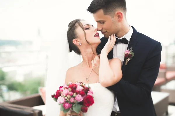 Casal bonito, noiva e noivo posando na varanda com fundo da cidade velha — Fotografia de Stock