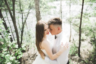 Öpüşen düğün çifti güzel manzarada kalıyor.