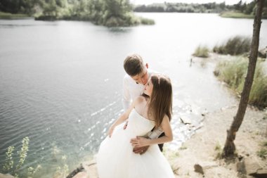 Öpüşen düğün çifti güzel manzarada kalıyor.