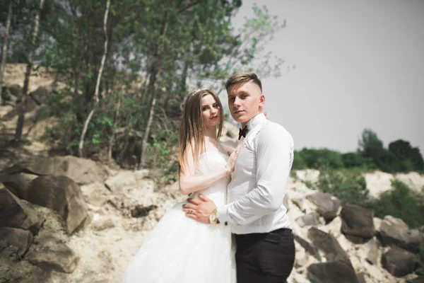 Casamento casal posando em grandes pedras. A noiva e o noivo — Fotografia de Stock