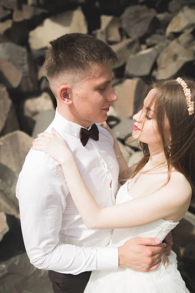 Couple de mariage amoureux embrasser et étreindre près des rochers sur un beau paysage — Photo