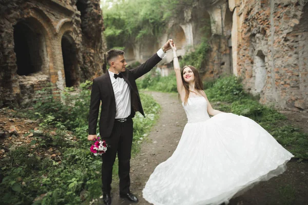 Krásná pohádka novomanželé pár objímání v blízkosti starého středověkého hradu — Stock fotografie