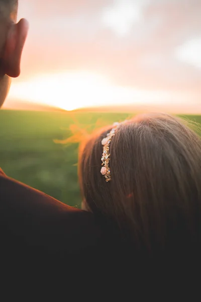 Hermosa pareja de boda, novia y novio posando en el campo durante la puesta del sol — Foto de Stock