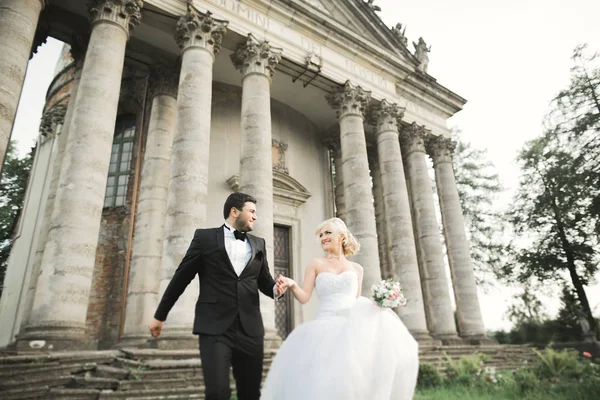 Hermosa boda romántica pareja de recién casados abrazos cerca del viejo castillo —  Fotos de Stock