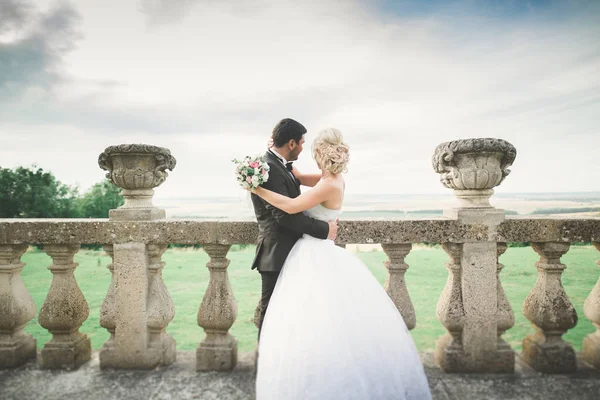 Casal romântico bonito casal de recém-casados abraçando perto do castelo velho — Fotografia de Stock