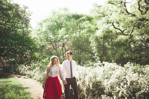 Stilvolle schöne glückliche Hochzeitspaar küsst und umarmt im botanischen Garten — Stockfoto