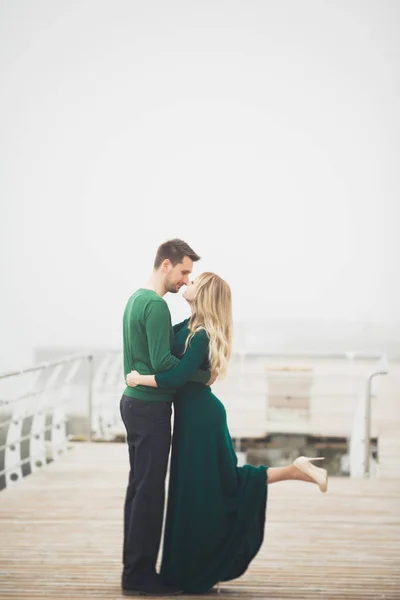 Preciosa pareja besándose y abrazándose en un muelle de mar —  Fotos de Stock