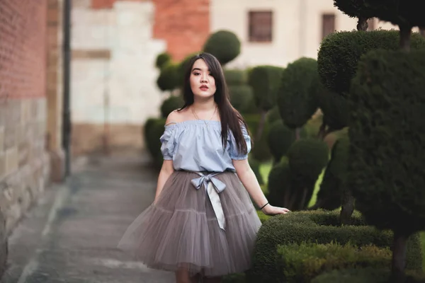 Junge asiatische Mädchen mit modernem Kleid posieren in einem alten Krakow — Stockfoto