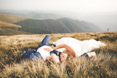 Harika bir gelin damada poz veriyor ve harika manzaralı dağlarda lüks bir tören yapıyor.