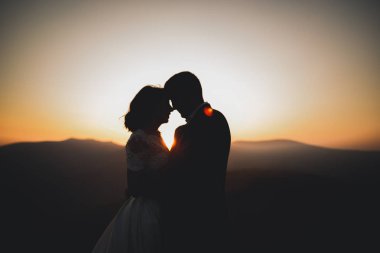 Düğün gününde damadın ve gelinin dağların eteklerinde mutlu mesut evlenecekler. Doğada mutlu evlilikler, yumuşak güneşli ışıklar.