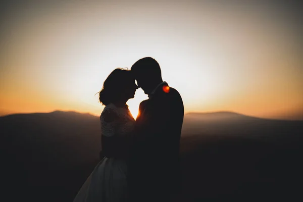 Joyeux beau couple de mariage mariée et marié le jour du mariage à l'extérieur sur le rocher des montagnes. Couple mariage heureux en plein air sur la nature, douces lumières ensoleillées — Photo