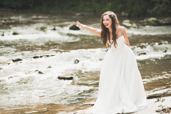 Hermosa novia feliz al aire libre en un bosque con rocas. Boda día perfecto — Foto de Stock