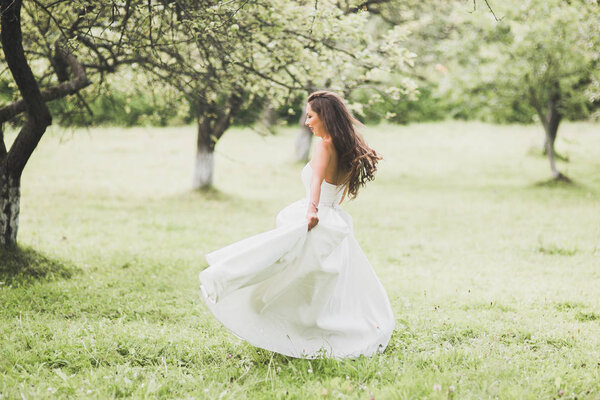 Beautiful bride spinning with perfect dress in the park.