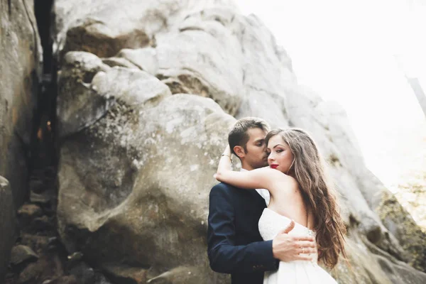 Splendida sposa, sposo baciare e abbracciare vicino alle scogliere con vista mozzafiato — Foto Stock