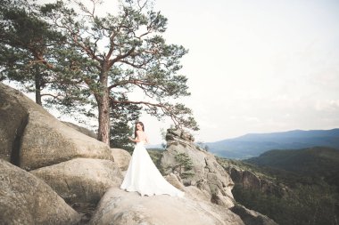 Güzel gelin orman kayalar ile poz bir buket ile. Açık havada
