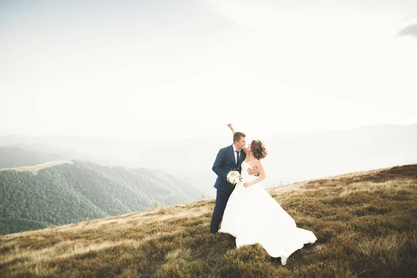 Hochzeitspaar posiert bei Sonnenuntergang am Hochzeitstag. Braut und Bräutigam verliebt — Stockfoto