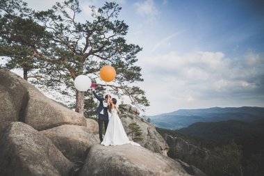 Güzel düğün çift, gelin ve damat, arka planda dağların aşık