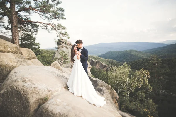 Couple de mariage amoureux embrasser et étreindre près des rochers sur un beau paysage — Photo