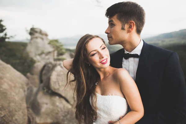 Linda noiva, noivo beijando e abraçando perto das falésias com vistas deslumbrantes — Fotografia de Stock