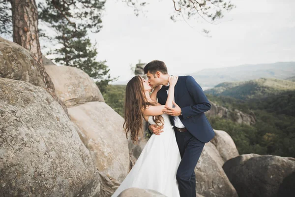 Matrimonio coppia innamorata baciare e abbracciare vicino rocce sul bellissimo paesaggio — Foto Stock