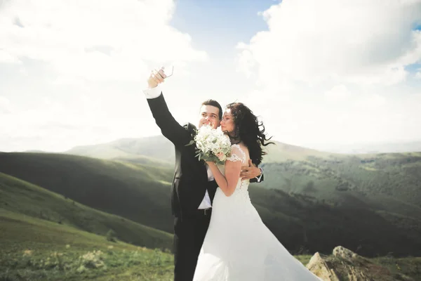 Coppia appena sposata in cima alla montagna scattare foto selfie — Foto Stock