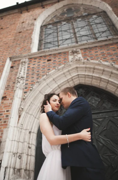 Lindo casamento casal, noiva, noivo posando perto de idade portão edifício — Fotografia de Stock