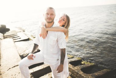 Deniz, mavi gökyüzü yakınındaki taş poz romantik sevgi dolu Çift