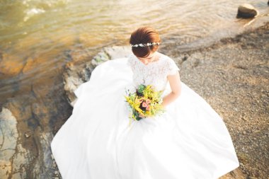 Güzel bayan, nehir kenarında poz bir gelinlik gelin