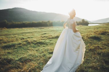 Gelin gelinlik çim güzel manzara arka plan ile poz