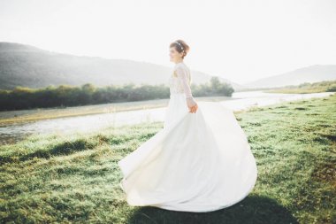 Gelin gelinlik çim güzel manzara arka plan ile poz