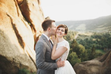 Öpüşen düğün çifti güzel manzarada kalıyor.