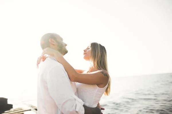 Glücklich frisch verheiratetes junges Hochzeitspaar feiert und hat Spaß am schönen Sonnenuntergang am Strand — Stockfoto