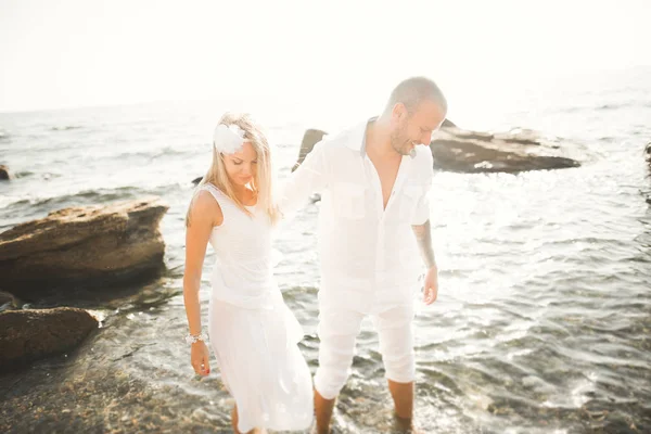 Couple de mariage baisers et câlins sur les rochers près de la mer bleue — Photo