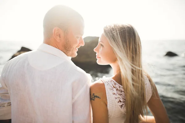 Glücklich frisch verheiratetes junges Hochzeitspaar feiert und hat Spaß am schönen Sonnenuntergang am Strand — Stockfoto