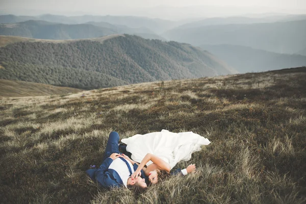Felice coppia di nozze posa su un bellissimo paesaggio in montagna — Foto Stock