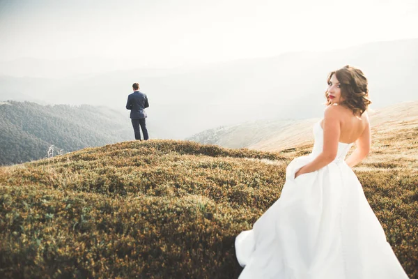 Jovem casal recém-casado, noiva e noivo beijando, abraçando na visão perfeita das montanhas, céu azul — Fotografia de Stock