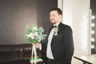 Güzel adam, damat poz veriyor ve düğüne hazırlanıyor.