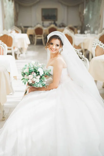 Mooie bruid met bruiloft boeket poseren in hotel — Stockfoto