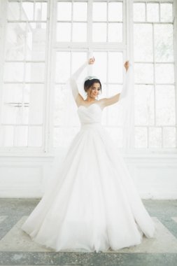 Güzel gelin gelinlik uzun tam etek, beyaz arka plan ile dans ve gülümse