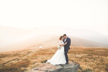 Harika bir gelin damada poz veriyor ve harika manzaralı dağlarda lüks bir tören yapıyor.