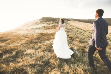 Harika bir gelin damada poz veriyor ve harika manzaralı dağlarda lüks bir tören yapıyor.